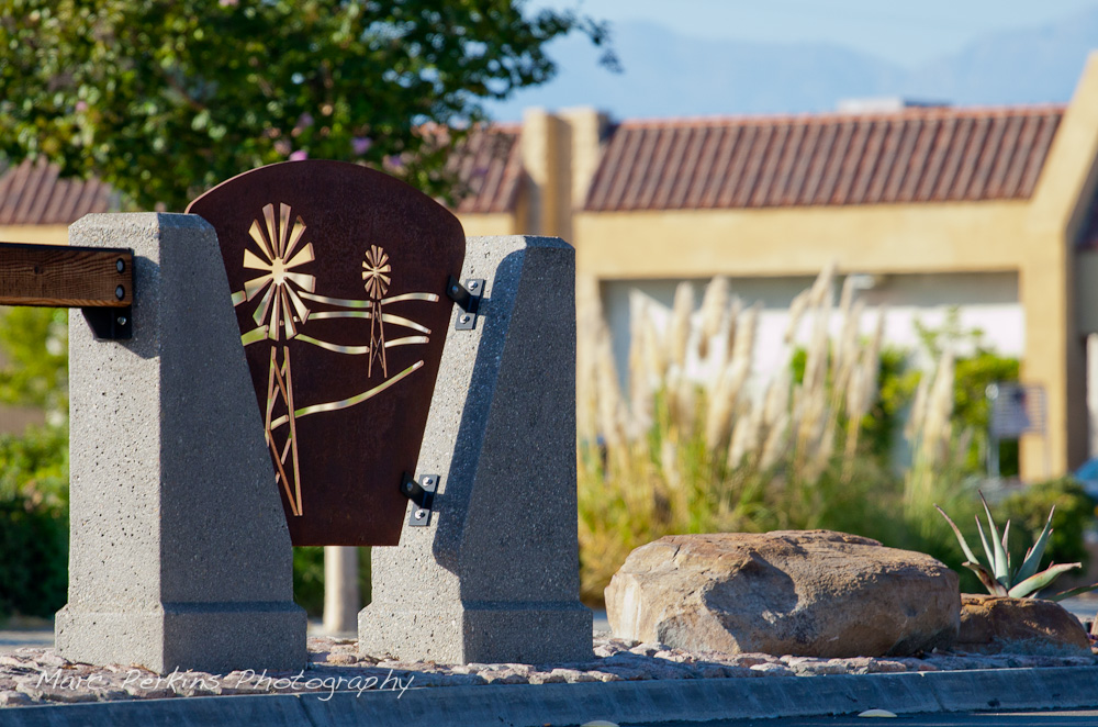 Iron plates with windmill cutouts play a key part of the Grand Avenue Beautification Project. This one is backlit by a late afternoon sun illuminating trees, rocks, and pampas grass. This was part of the 2015 rebuild of the Grand Avenue and Diamond Bar Boulevard intersection for Diamond Bar's 2015 "Grand Avenue Beautification" project, landscape architecture for the project was by David Volz Design.
