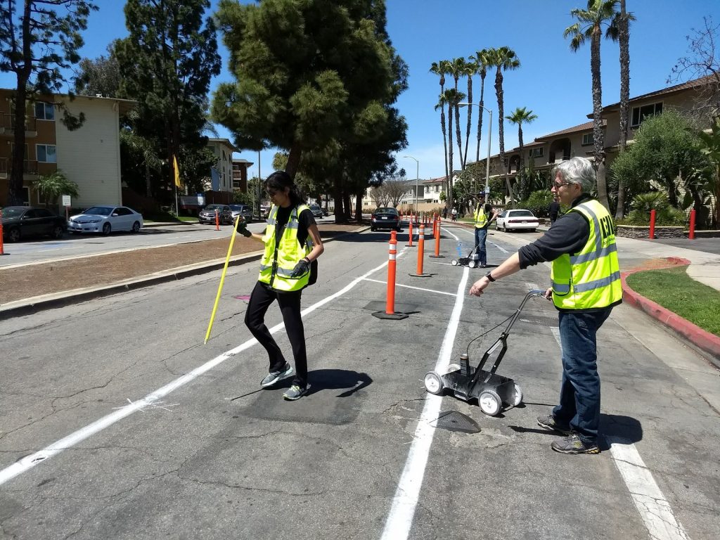 People install the demonstration protected bike lane along Merrimac Way in April 2018.