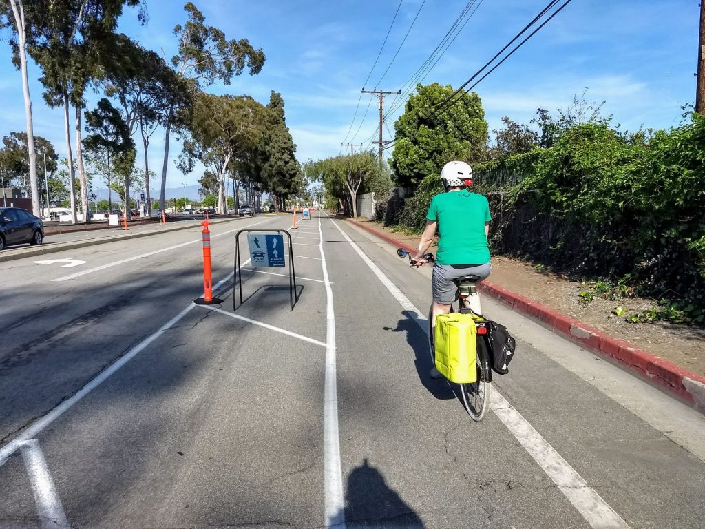 A bicyclist rides down the demonstration protected bike lane on Merrimac Way.